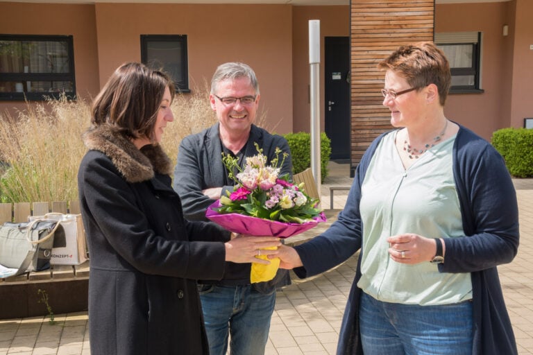 Eine Frau übergibt Silke Hachenberger einen Strauß Blumen