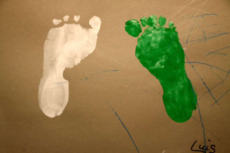 Kindliche Fußabdrücke in weißer und grüner Farbe.