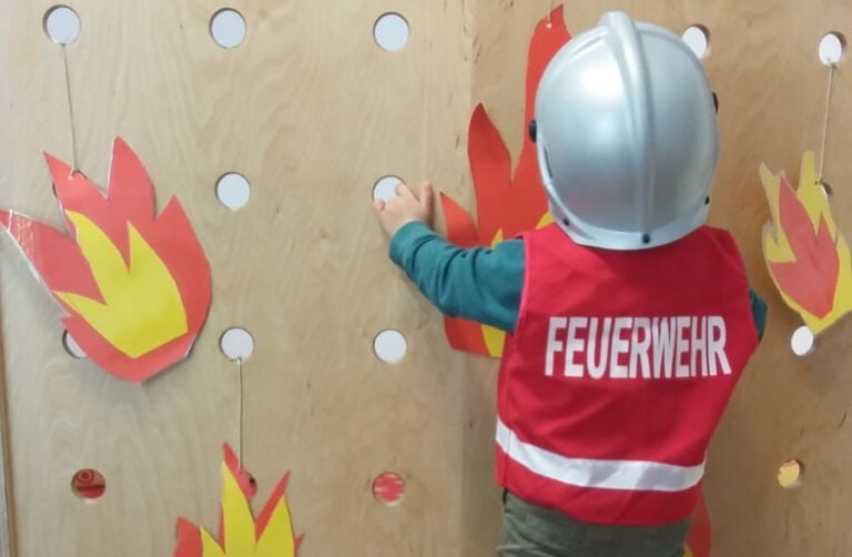 Kind mit Feuerwehrkostüm von hinten