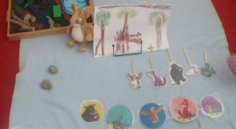 Kinderzeichnung sowie ausgeschnittene Figuren aus dem Grüffelo-Buch